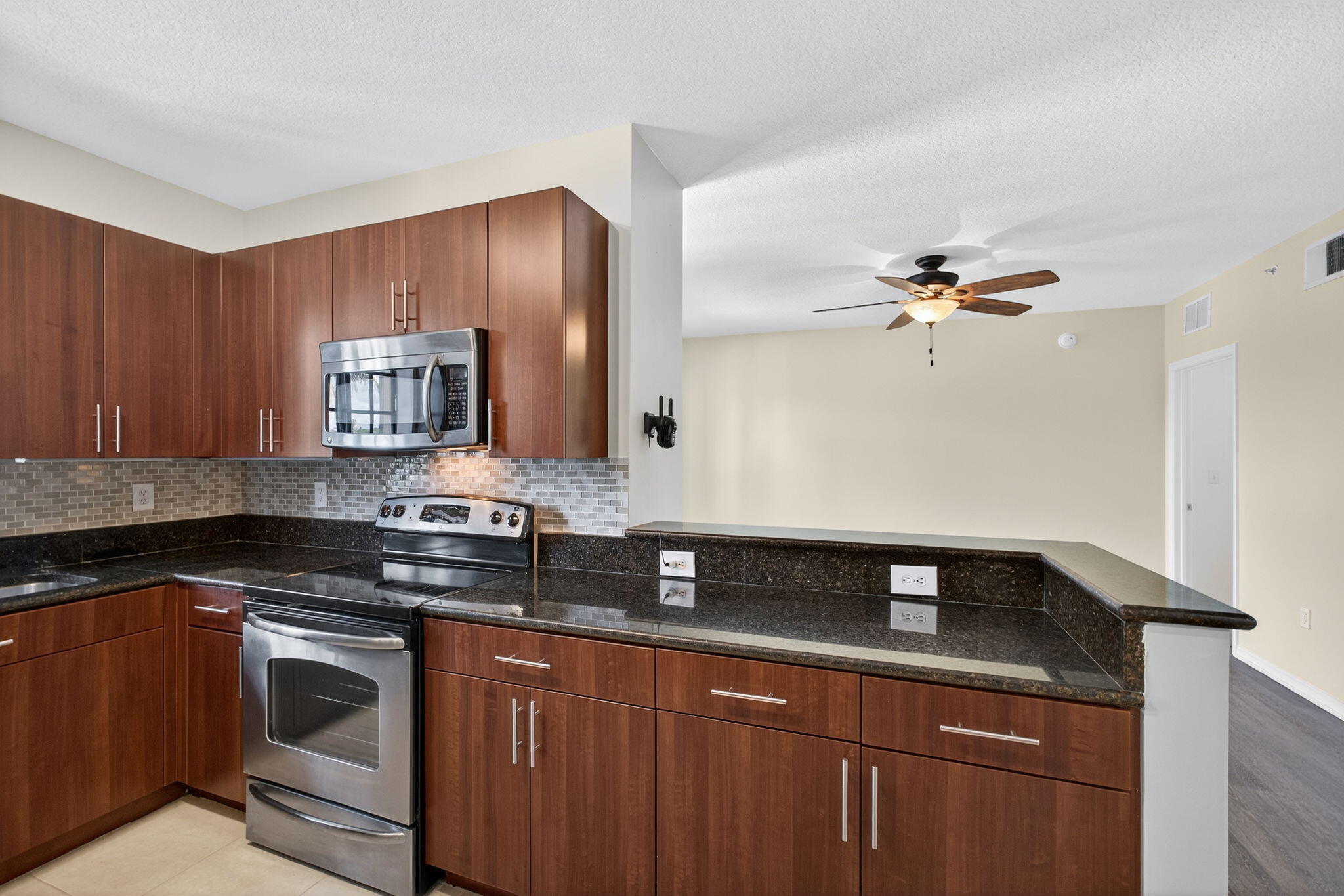 4907 Midtown Lane, Unit 1314 Palm Beach Gardens, FL 33418 - Photo 17 of 57 a kitchen with granite countertop a sink cabinets and stainless steel appliances