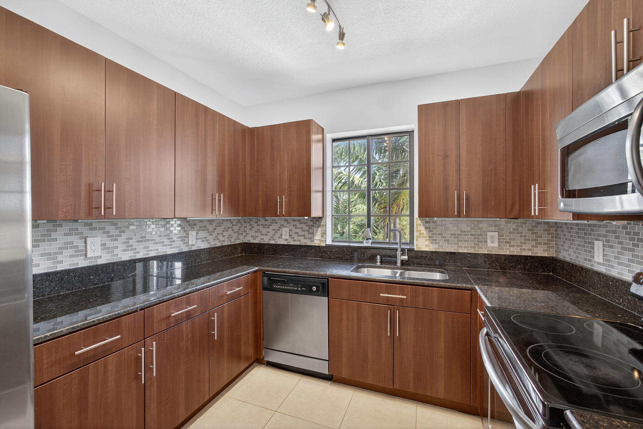 4907 Midtown Lane, Unit 1314 Palm Beach Gardens, FL 33418 - Photo 18 of 57 a kitchen with a sink stove and microwave
