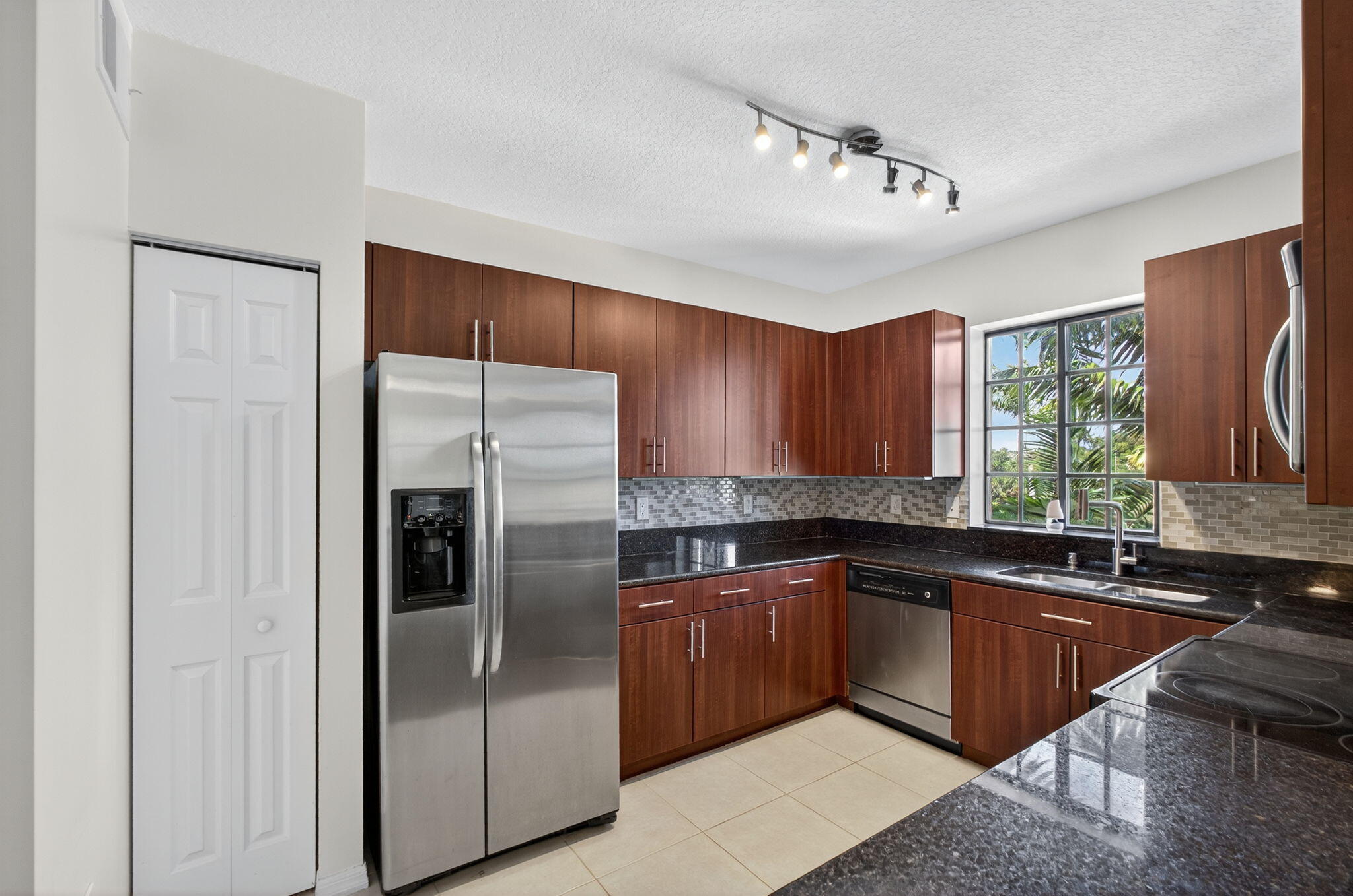 4907 Midtown Lane, Unit 1314 Palm Beach Gardens, FL 33418 - Photo 19 of 57 a kitchen with stainless steel appliances granite countertop a sink stove and refrigerator