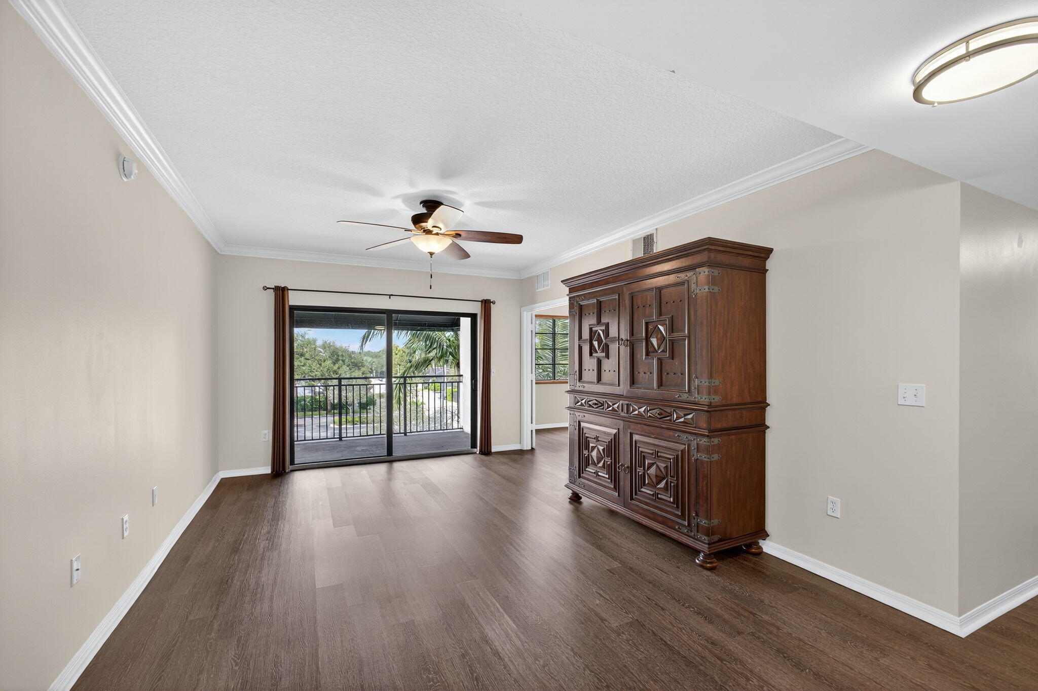 4907 Midtown Lane, Unit 1314 Palm Beach Gardens, FL 33418 - Photo 7 of 57 a view of an empty room with wooden floor and fan