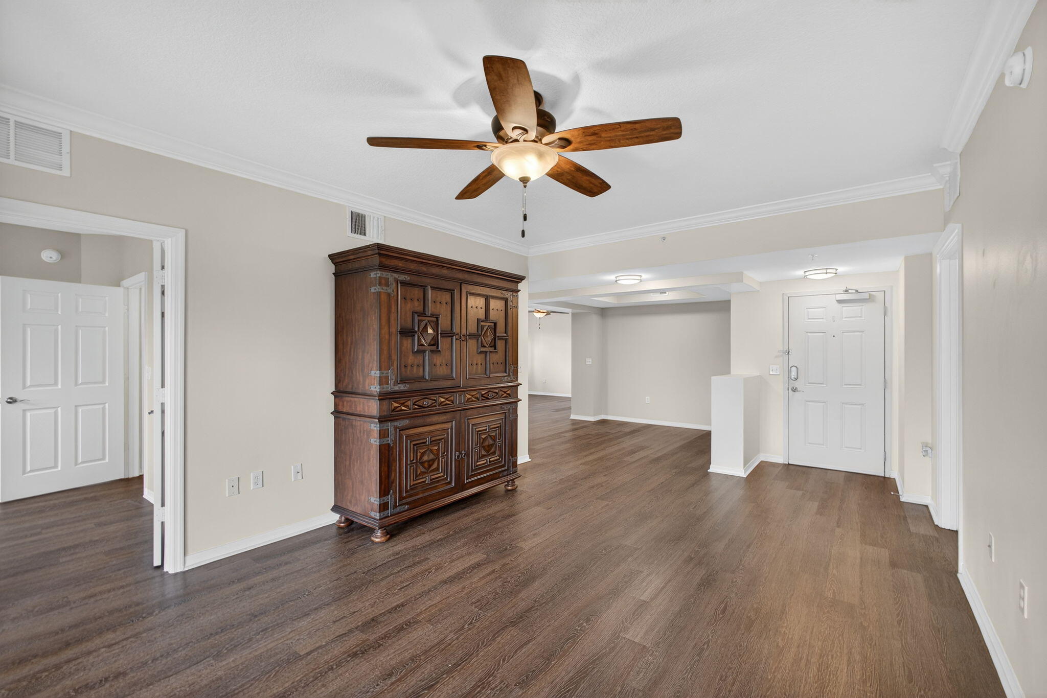 4907 Midtown Lane, Unit 1314 Palm Beach Gardens, FL 33418 - Photo 8 of 57 a view of an empty room with wooden floor and a ceiling fan