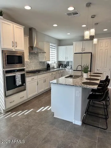 a kitchen with kitchen island granite countertop a stove sink and microwave