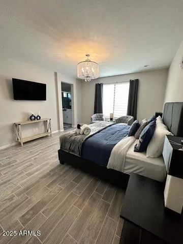 a spacious bedroom with a bed and a flat screen tv