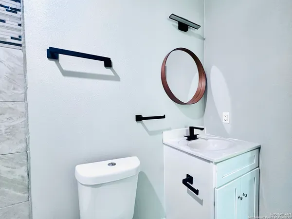 a bathroom with a sink a toilet and a mirror