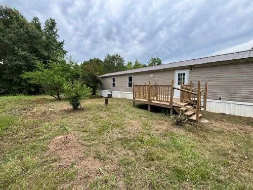 a view of a house with backyard and chairs