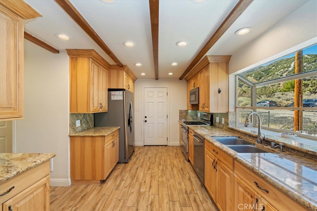 7337 Sequoia Road Wrightwood, CA 92397 - Photo 12 of 52 a large kitchen with a large window a sink and stainless steel appliances