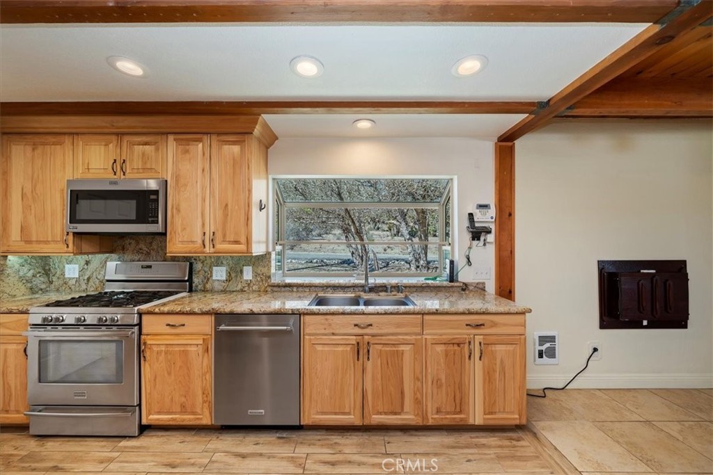 7337 Sequoia Road Wrightwood, CA 92397 - Photo 13 of 52 a kitchen with stainless steel appliances granite countertop a stove a sink and a microwave