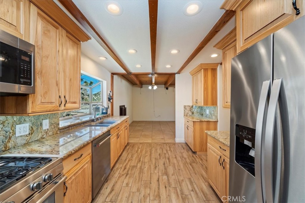 7337 Sequoia Road Wrightwood, CA 92397 - Photo 14 of 52 a kitchen with stainless steel appliances granite countertop a refrigerator a sink dishwasher a stove and white countertops with wooden floor