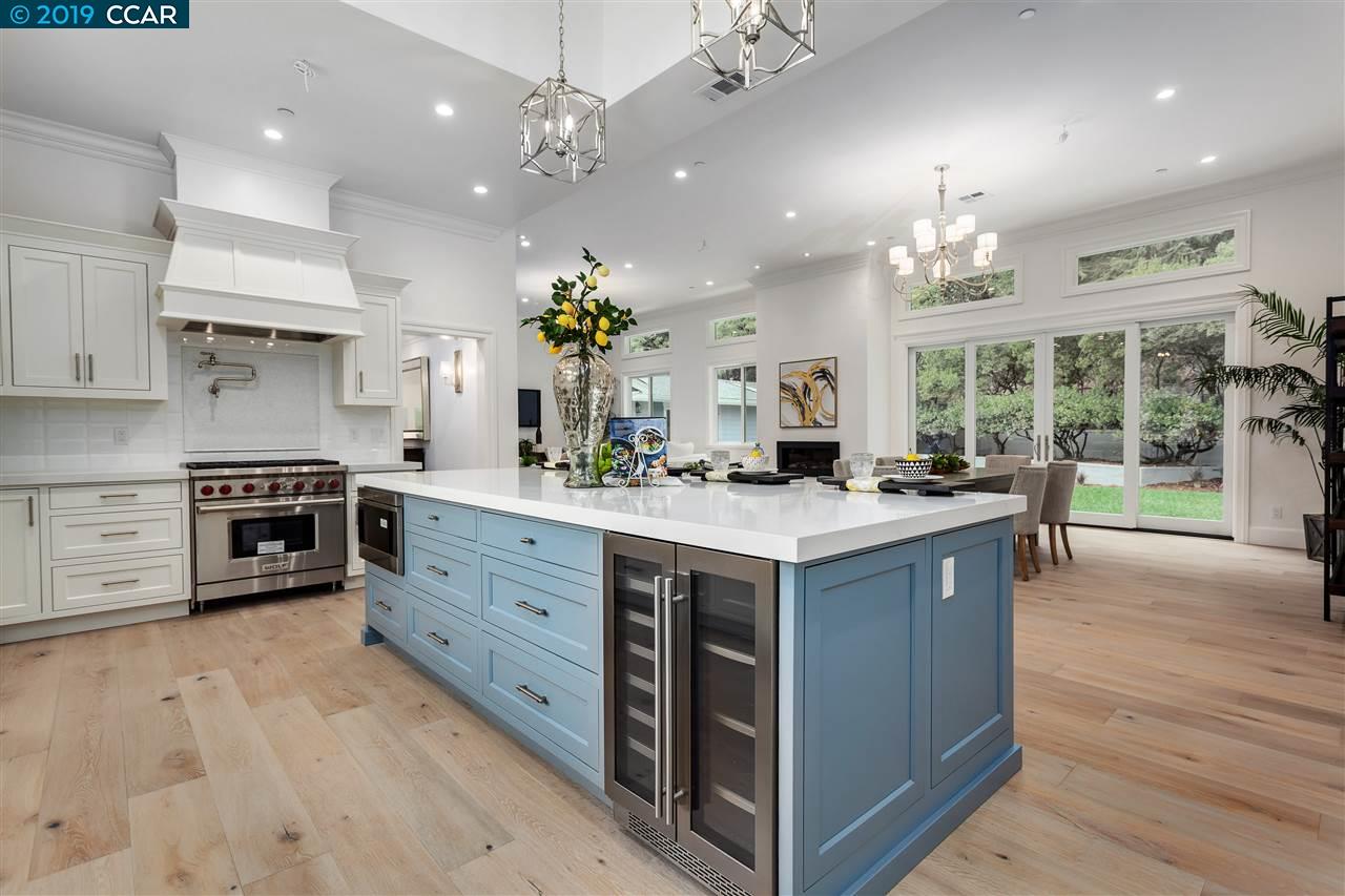a large kitchen with kitchen island a chandelier and wooden floors