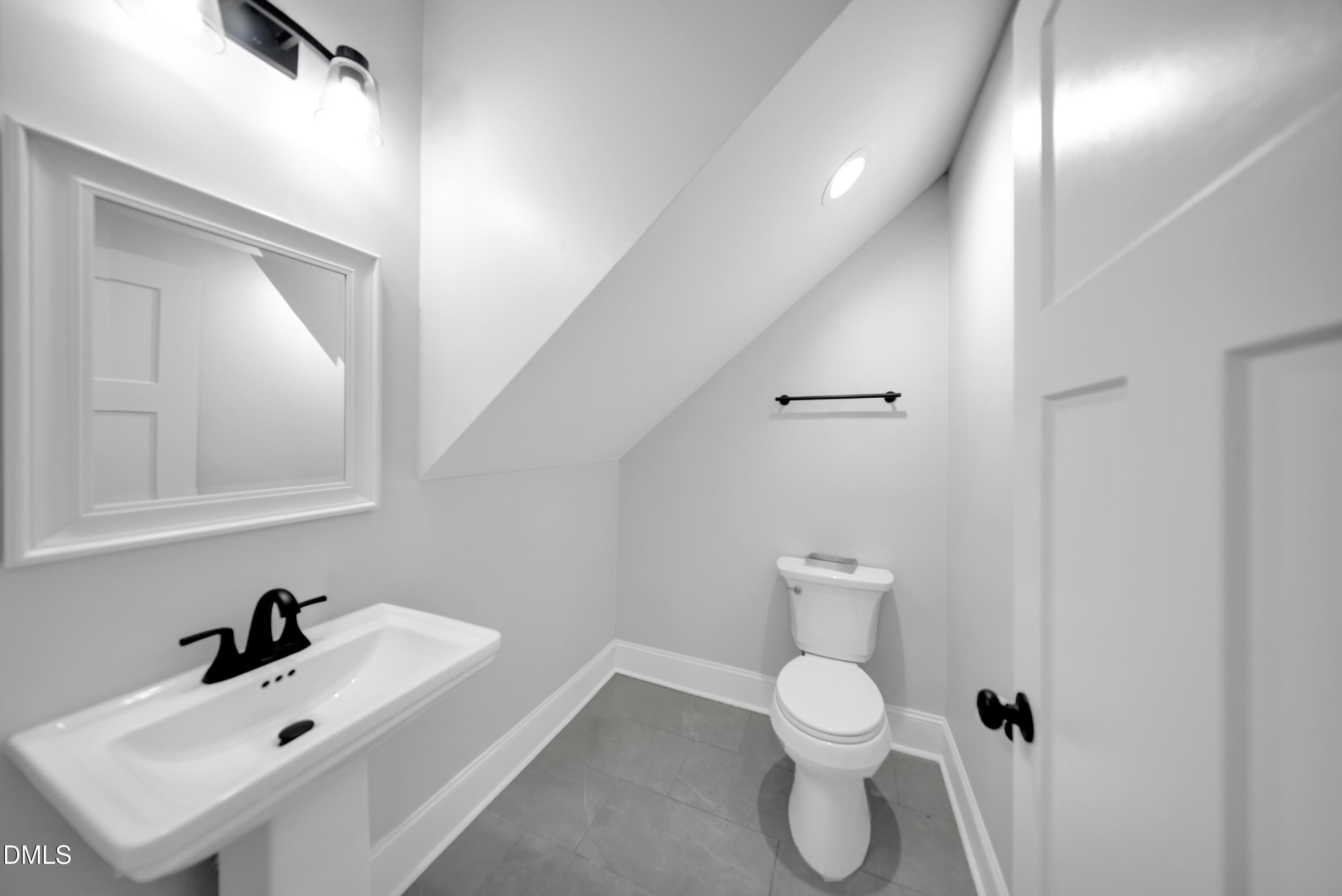 3908 Booker Avenue Durham, NC 27713 - Photo 16 of 71 a bathroom with a toilet sink and mirror