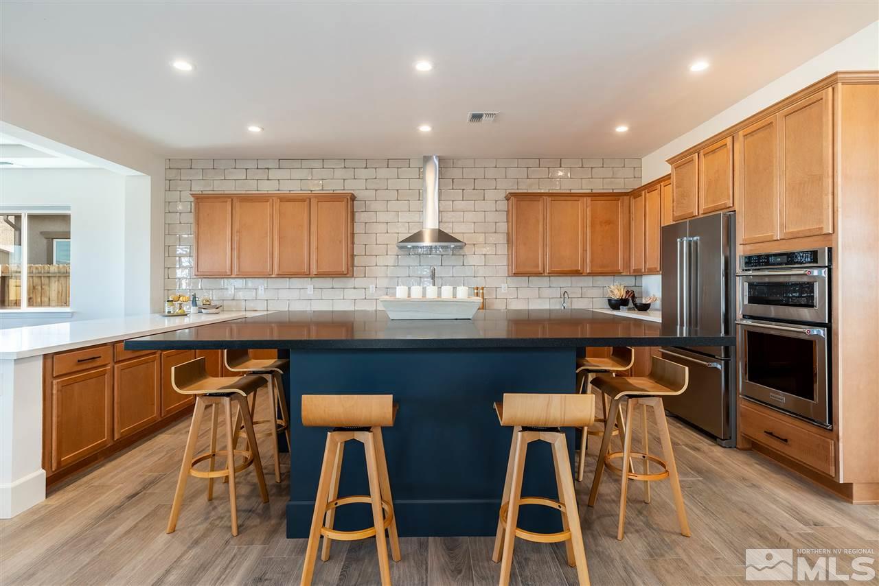 2337 Stone Rise Road Reno, NV 89521 - Photo 6 of 25 a kitchen with stainless steel appliances granite countertop a stove top oven a sink dishwasher a dining table and chairs with wooden floor