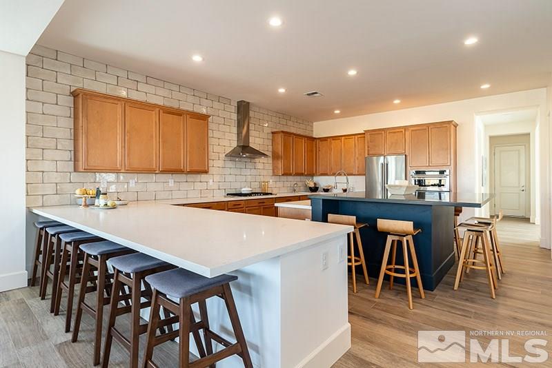 2337 Stone Rise Road Reno, NV 89521 - Photo 7 of 25 a kitchen with stainless steel appliances kitchen island granite countertop a table chairs sink and cabinets