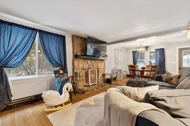 a living room with furniture fireplace and a large window