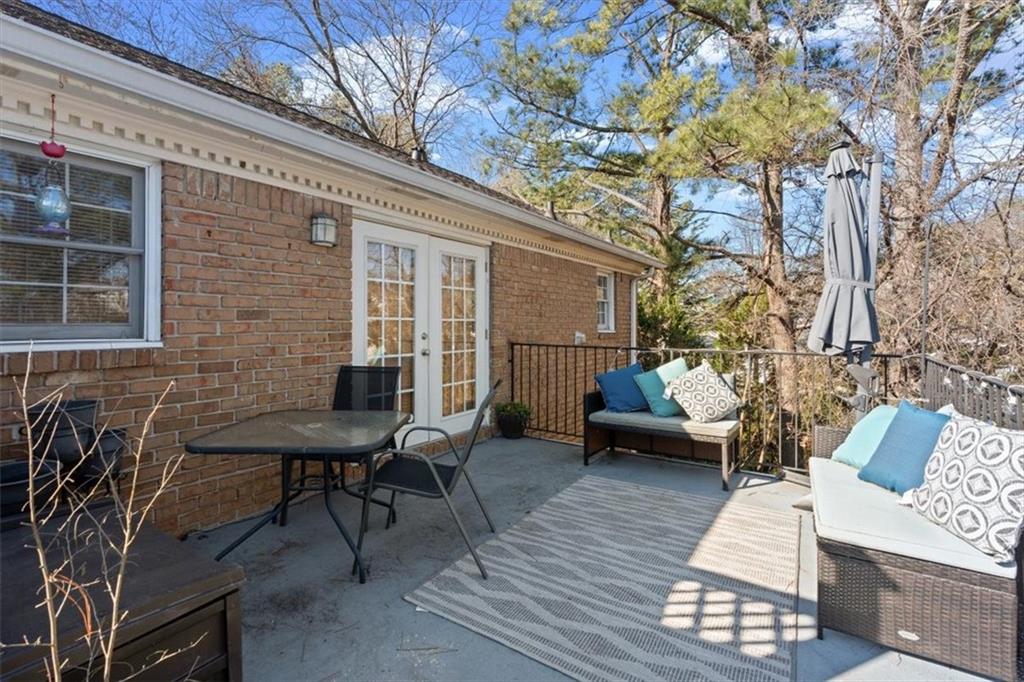 1101 Collier Road Northwest, Unit T5 Atlanta, GA 30318 - Photo 23 of 32 a view of a patio with couches and table and chairs with wooden floor and fence