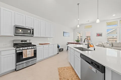 a kitchen with sink a stove and cabinets