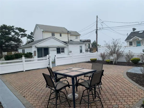 a view of a patio with table and chairs with wooden floor and fence
