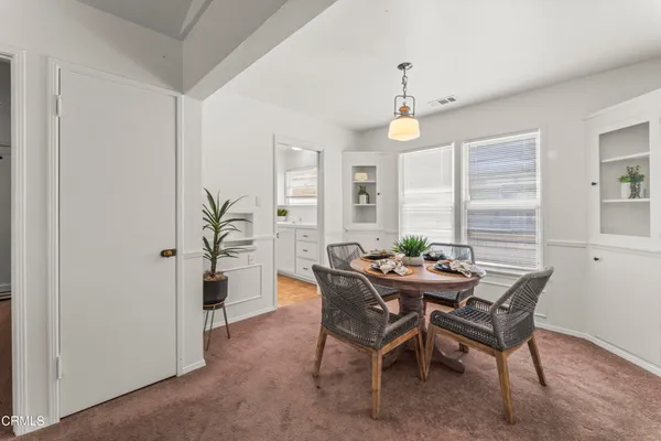 a dining room with furniture window and wooden floor