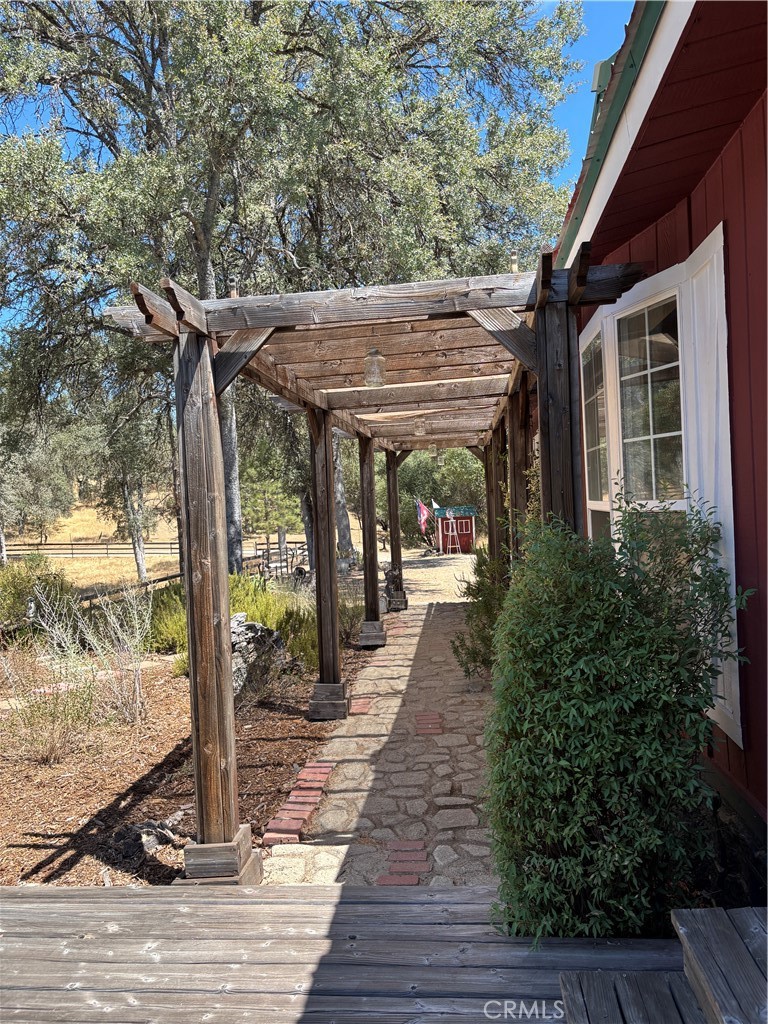 4060 Indian Peak Road Mariposa, CA 95338 - Photo 39 of 60 a view of a patio with table and chairs under an umbrella with wooden floor