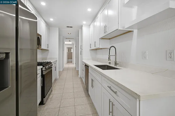 a kitchen with stainless steel appliances granite countertop a sink and a refrigerator