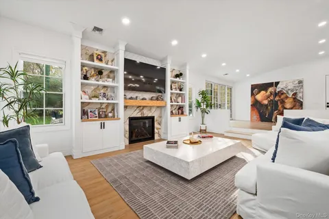 a living room with furniture a fireplace and a large window