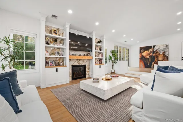 a living room with furniture a fireplace and a large window