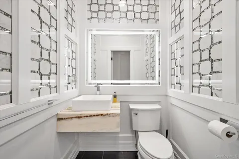 a bathroom with a sink a toilet and a mirror