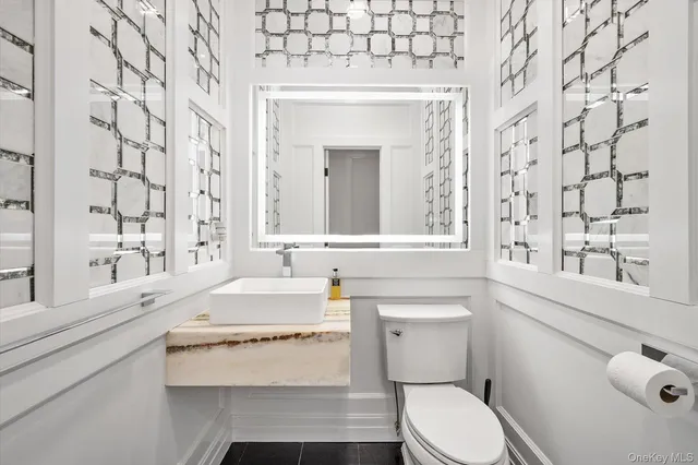 a bathroom with a sink a toilet and a mirror