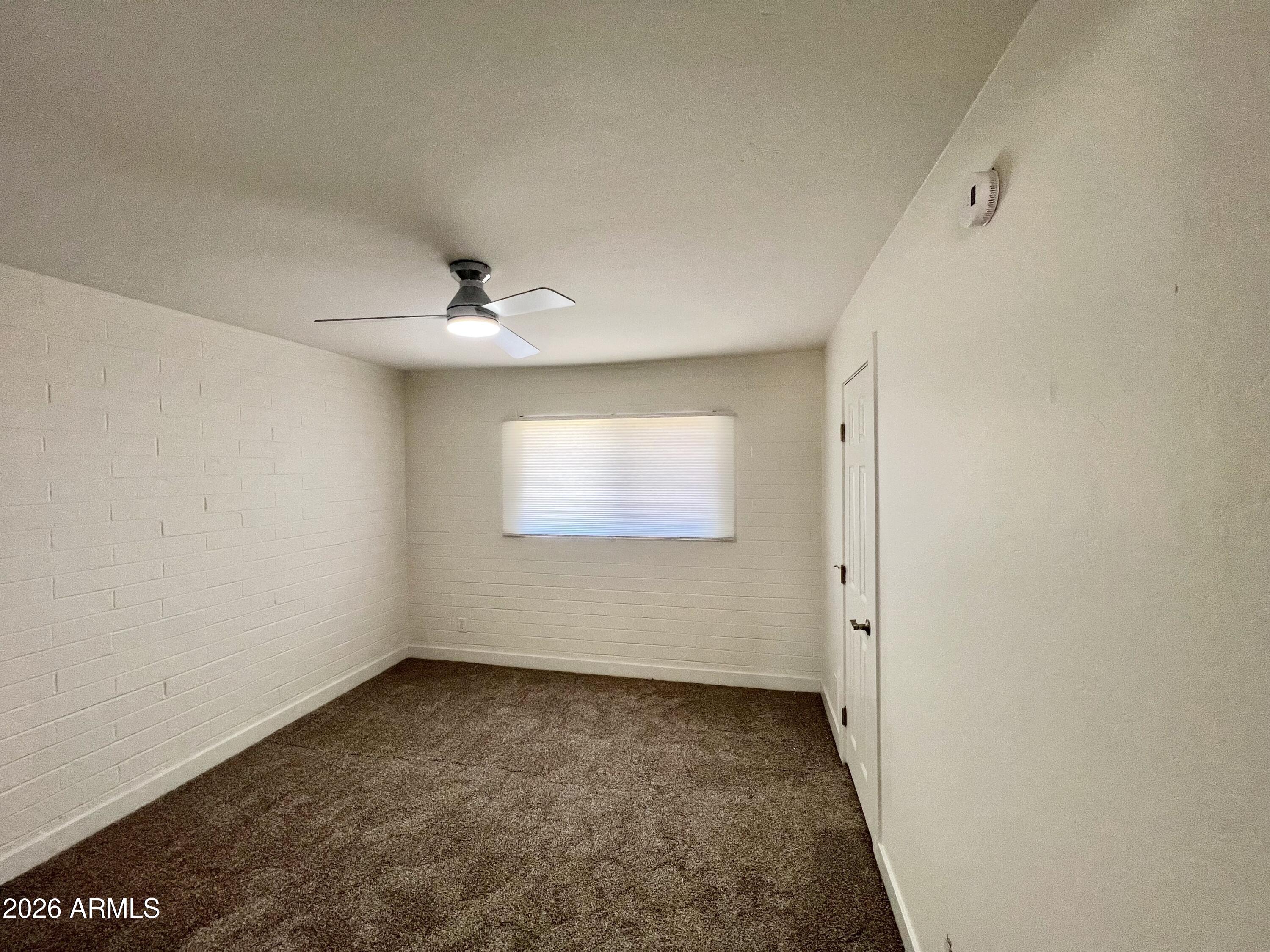 3818 West Ruth Avenue Phoenix, AZ 85051 - Photo 15 of 20 an empty room with a ceiling fan and window
