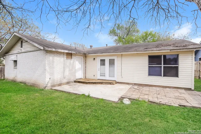 a backyard of a house with lots of green space and wooden fence