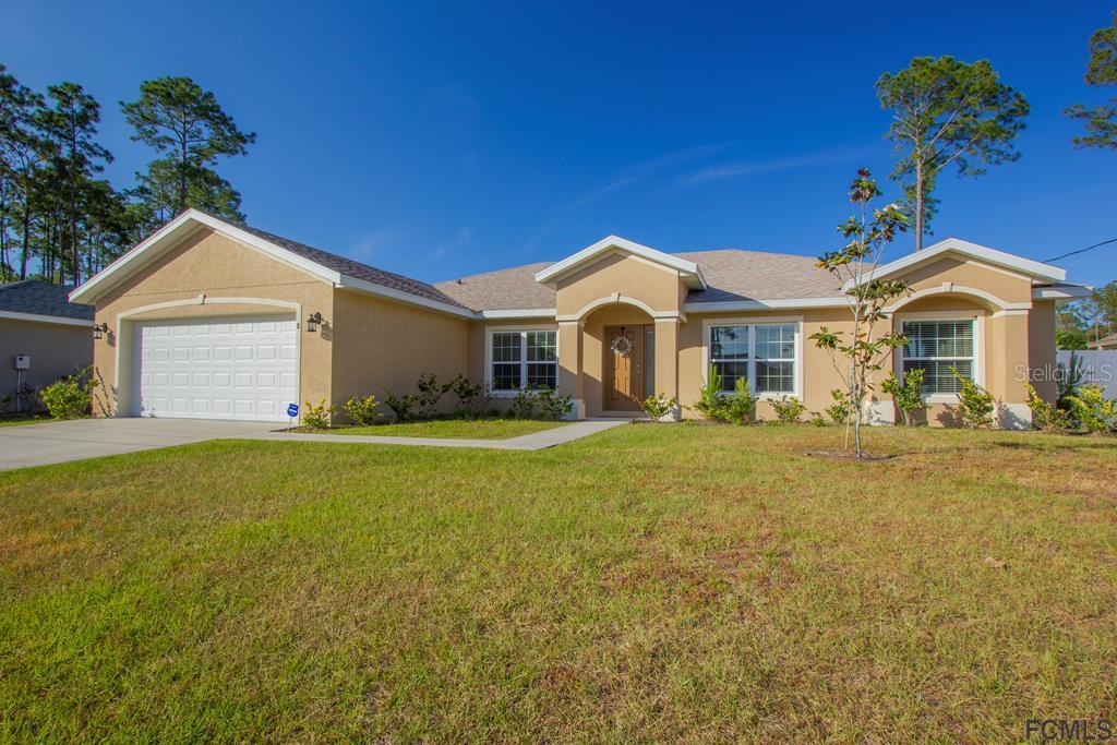 8 Riptide Place Palm Coast, FL 32164 - Photo 1 of 1 a front view of a house with a garden and yard