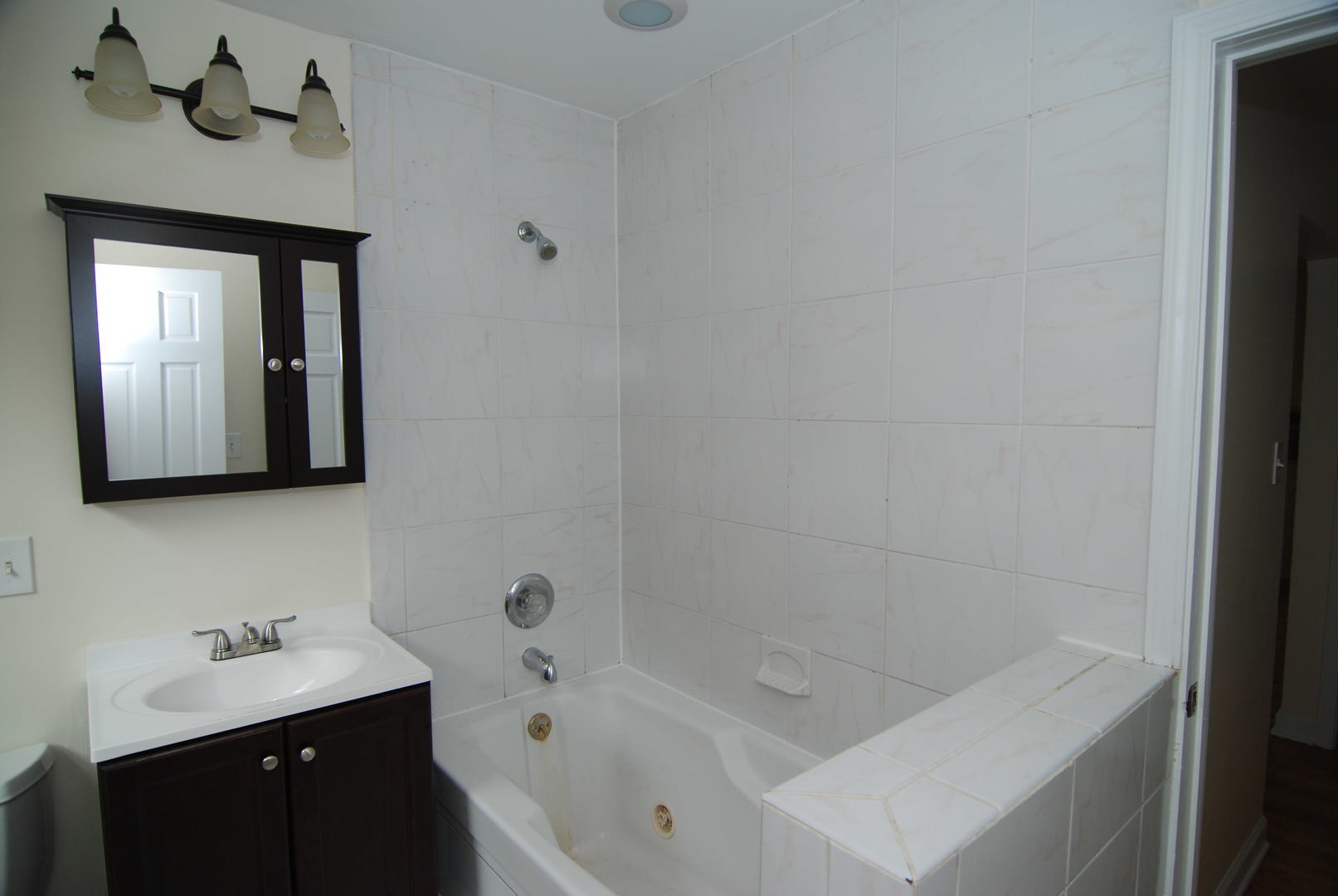 7530 North Ridge Boulevard, Unit 2E Chicago, IL 60645 - Photo 15 of 15 a bathroom with a bathtub sink and mirror