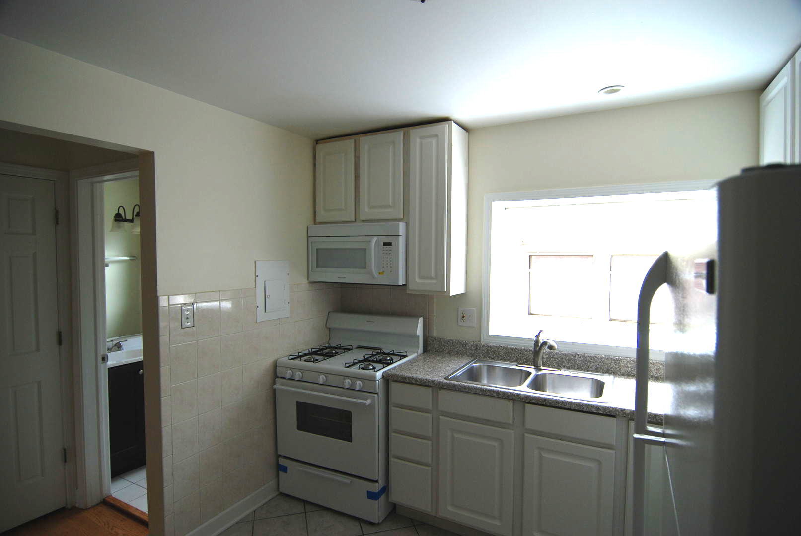 7530 North Ridge Boulevard, Unit 2E Chicago, IL 60645 - Photo 3 of 15 a kitchen with stainless steel appliances granite countertop a sink stove and refrigerator