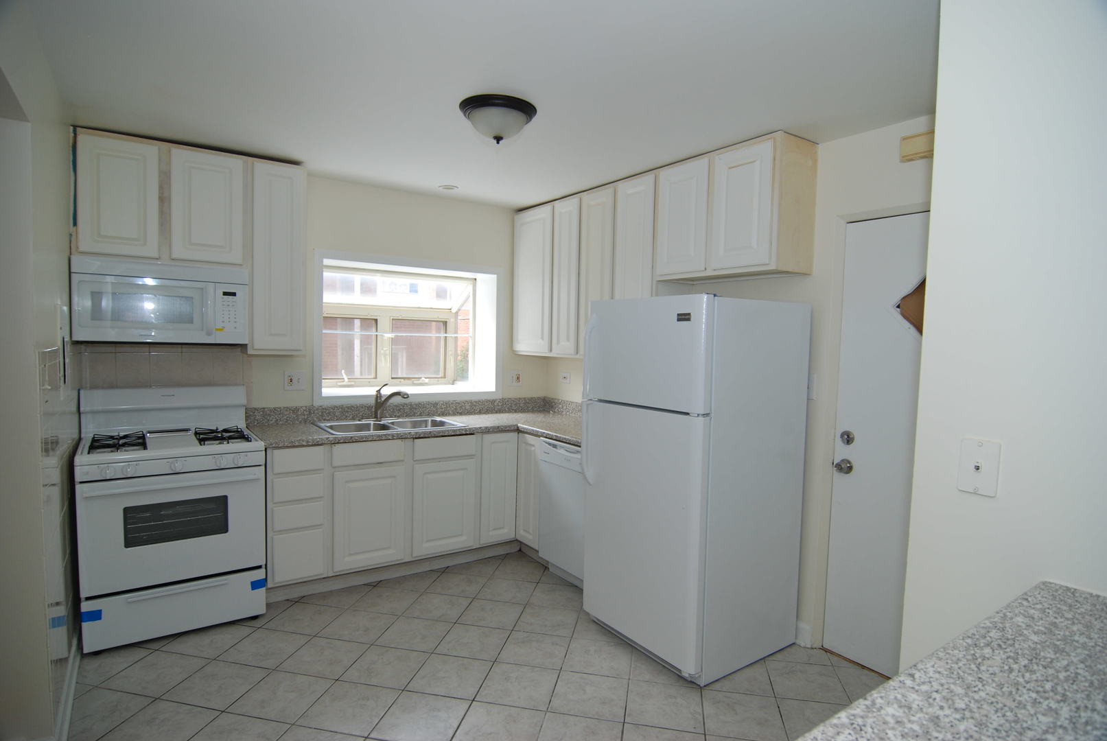 7530 North Ridge Boulevard, Unit 2E Chicago, IL 60645 - Photo 5 of 15 a kitchen with white cabinets and white appliances