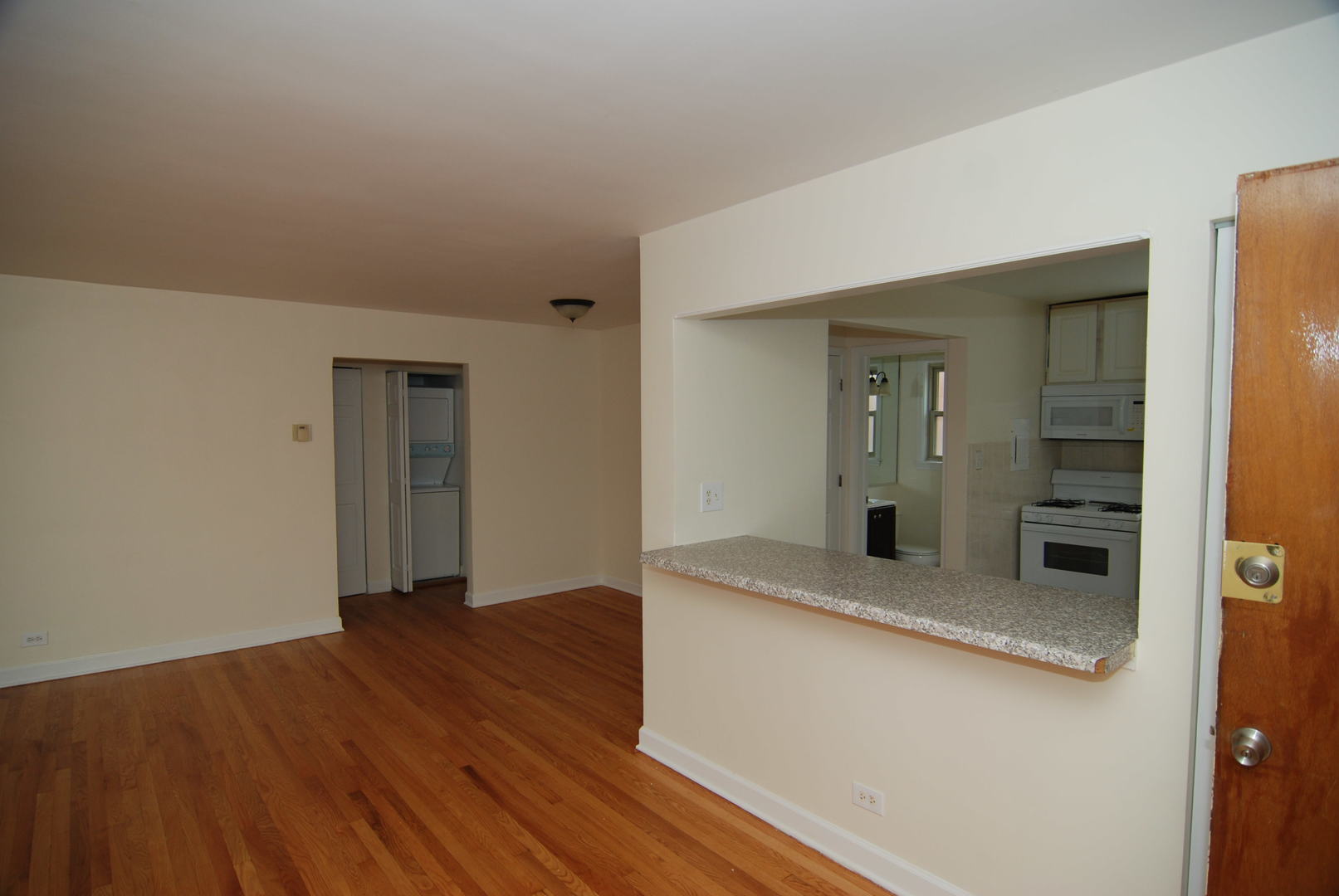 7530 North Ridge Boulevard, Unit 2E Chicago, IL 60645 - Photo 7 of 15 a view of a hallway with wooden floor and a kitchen