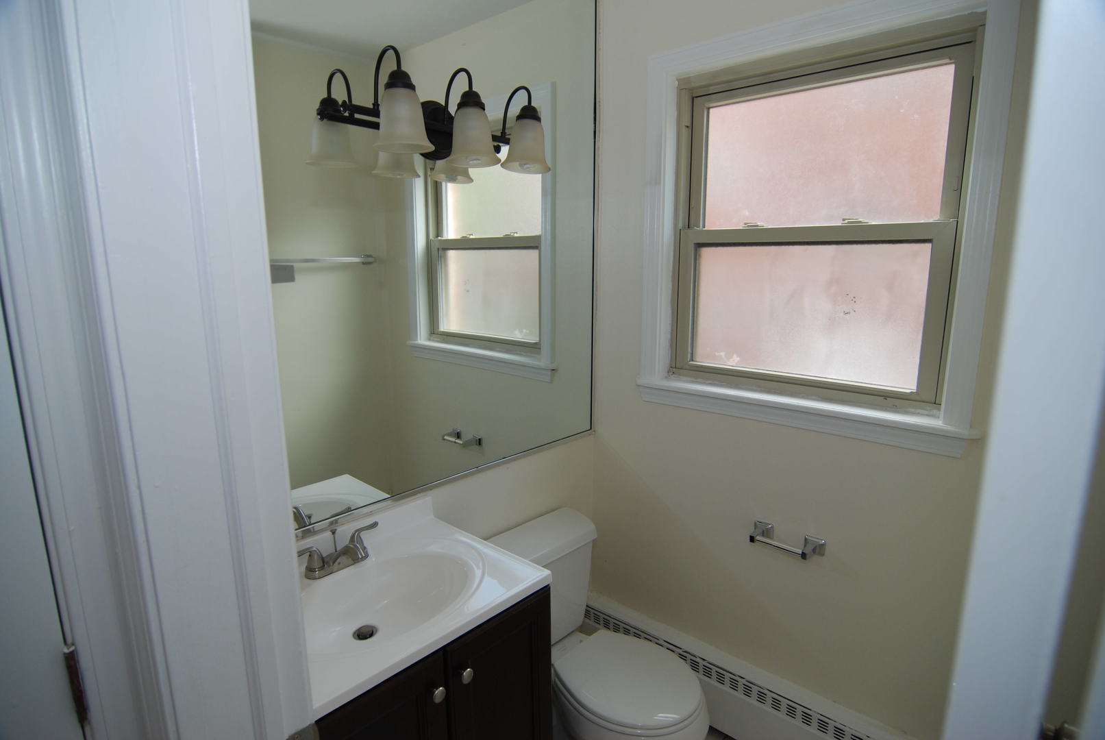 7530 North Ridge Boulevard, Unit 2E Chicago, IL 60645 - Photo 9 of 15 a bathroom with a toilet sink vanity and window
