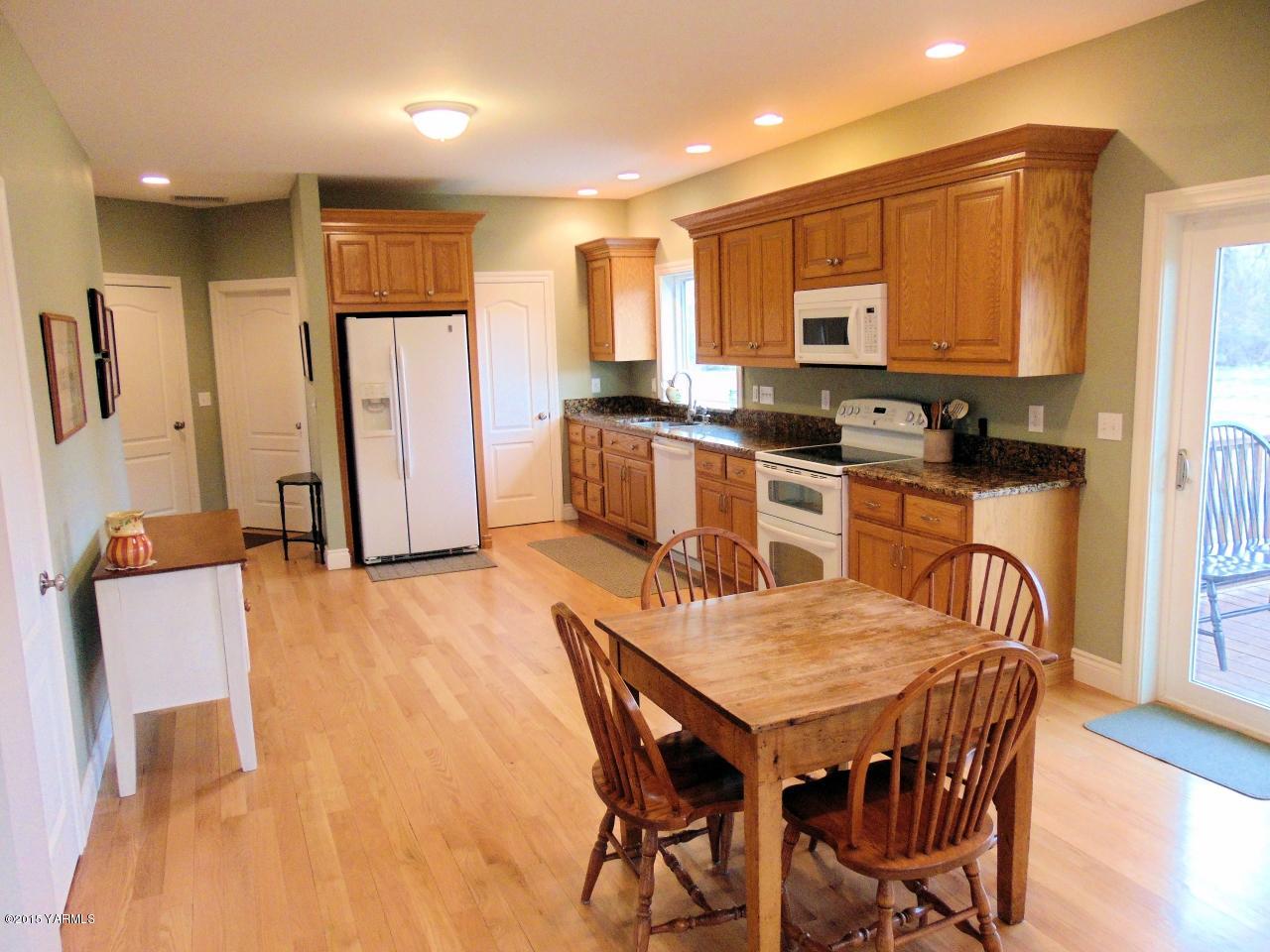 3801 Wiley Road Yakima, WA 98903 - Photo 11 of 20 a kitchen with a table chairs refrigerator and microwave