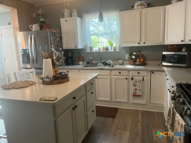 a kitchen with stainless steel appliances granite countertop a sink stove and cabinets