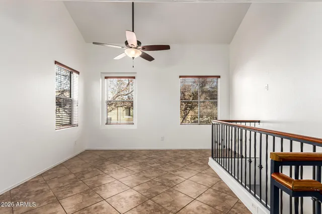 a view of a hallway with windows and chandelier fan