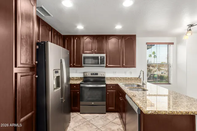 a kitchen with stainless steel appliances granite countertop a refrigerator stove and sink
