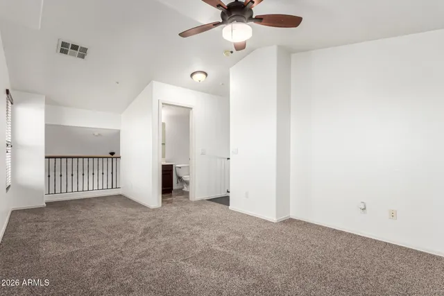 an empty room with windows and fan