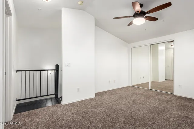 an empty room with a ceiling fan and a window