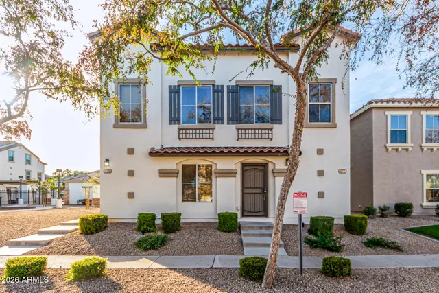 a front view of a house with a tree