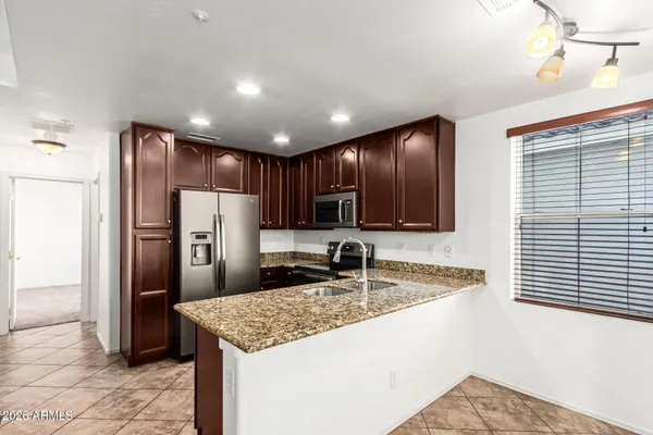 a kitchen with stainless steel appliances granite countertop a refrigerator and a sink