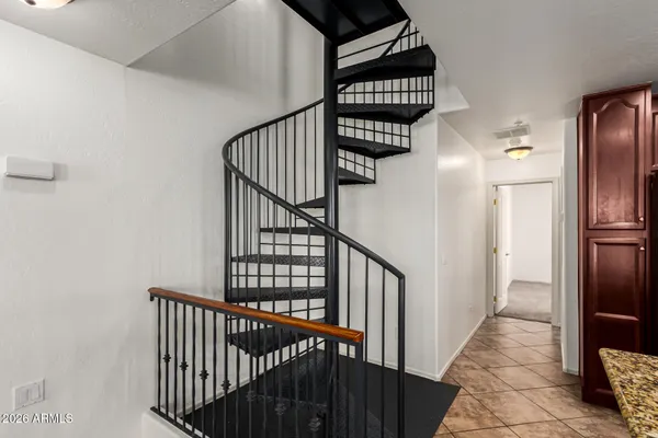 a view of staircase with railing and white walls