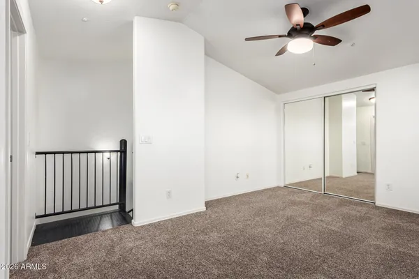 an empty room with a ceiling fan and a window
