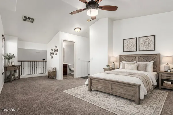 a spacious bedroom with a bed and a chandelier