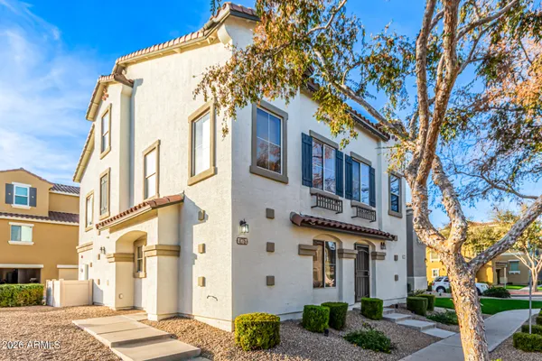 a front view of a multi story residential apartment building with yard and parking space