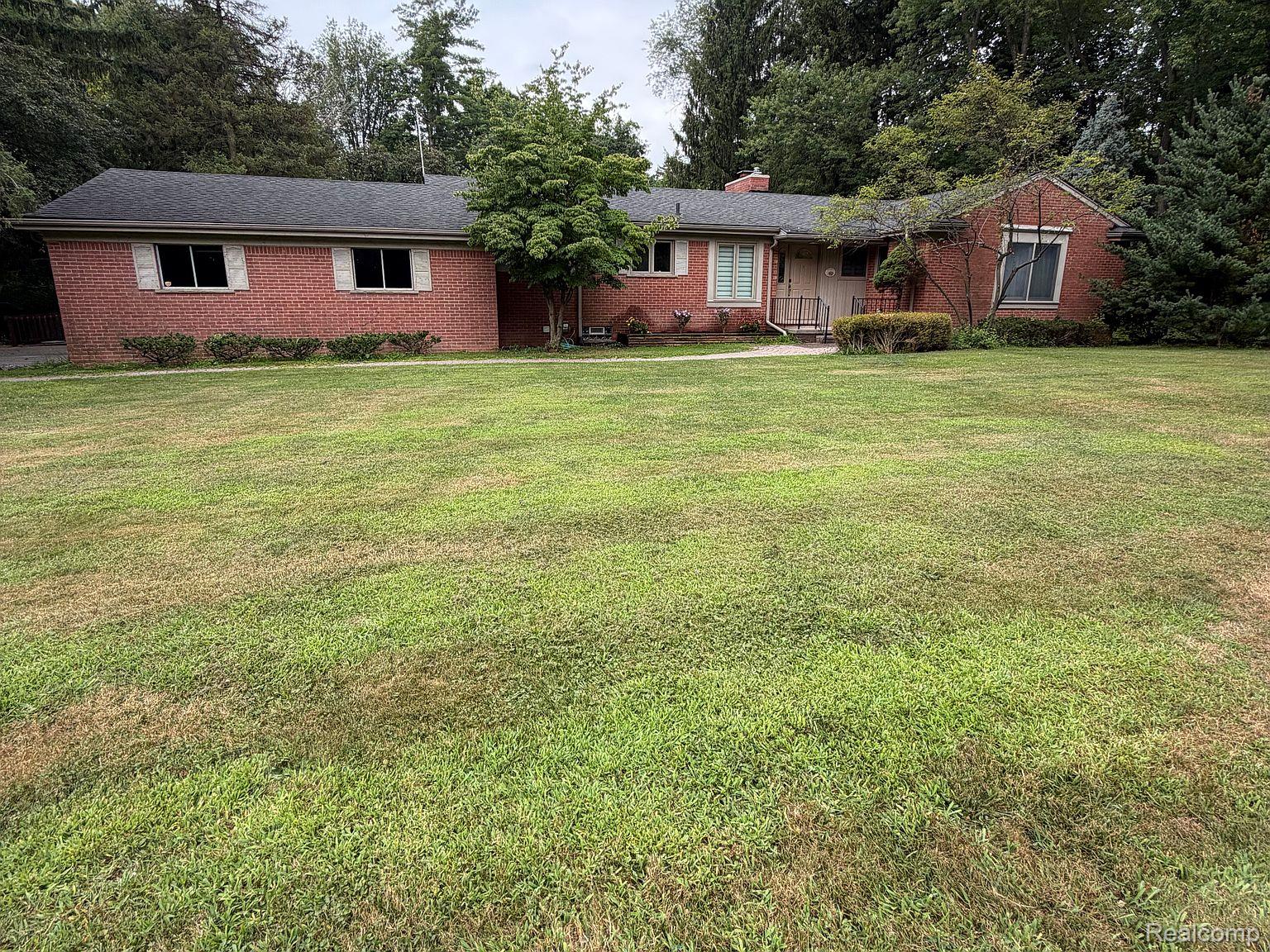 3520 Rayburn Road Bloomfield Hills, MI 48304 - Photo 2 of 26 Brick exterior with a dark shingle roof and mature trees