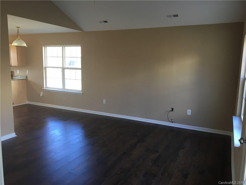 1119 Hannah Rae Court Charlotte, NC 28214 - Photo 6 of 12 an empty room with wooden floor and windows