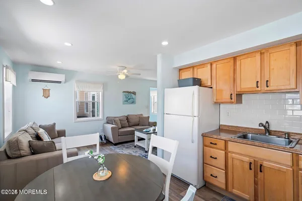 a living room with furniture and a refrigerator